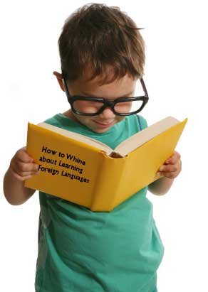 Small boy wearing glasses reading a book
